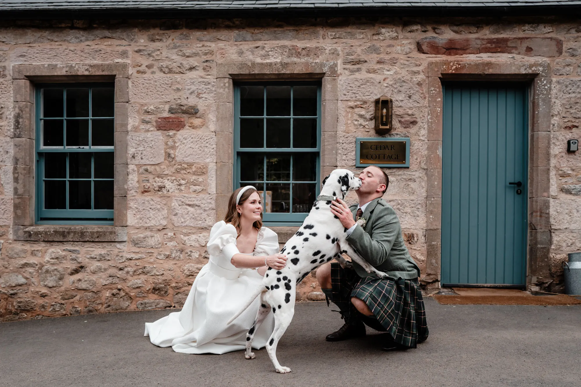 A wedding couple walking through Broxmouth Courtyard.
